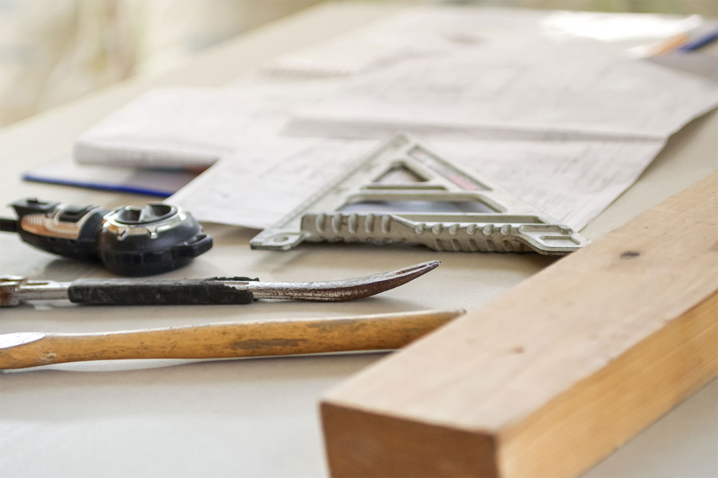 施工前の図面と工具を並べて準備する設備工事の作業風景