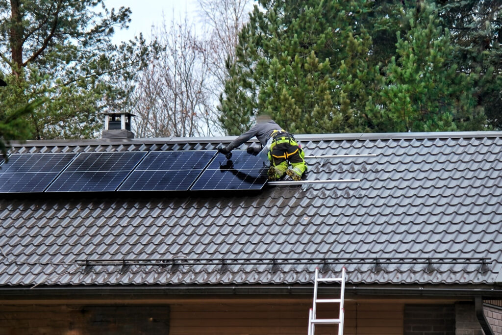 住宅屋根にソーラーパネルを設置する太陽光発電工事の施工風景